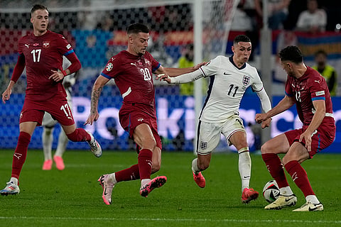 Phil Foden is challenged by Serbia players